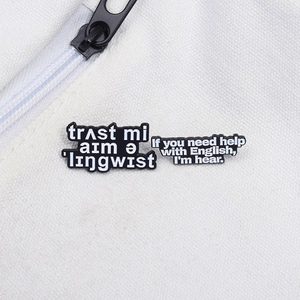 Macro view of black enamel pins with linguistic puns pinned on white canvas bag