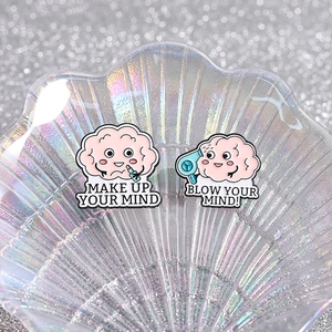 Pink brain enamel pins set with Make Up Your Mind and Blow Your Mind slogans