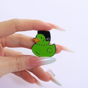 Handheld view of a green Frankenstein duck enamel pin made of zinc alloy lacquer