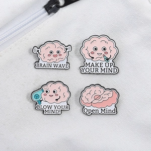 Set of four cute pink brain enamel pins with creative medical cartoon designs on fabric