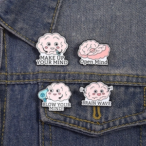 Close-up of four creative pink brain enamel pins on a blue denim jacket pocket