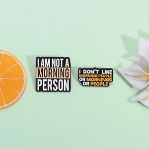 Badges en émail avec citations 'I AM NOT A MORNING PERSON' sur fond vert menthe