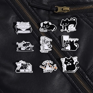 Detailed set of nine funny cartoon cat enamel pins displayed on a black leather jacket