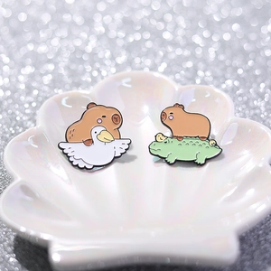 Cute Capybara enamel pins featuring capybara riding a white bird and a green crocodile