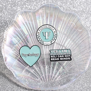Blue psychology enamel pins featuring Psi symbol and heart shape on decorative background