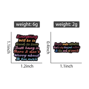 Detail view of colorful enamel pins with English quotes showing exact size and weight metrics