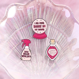 Three-piece pink enamel brooch set featuring magical book-themed crystal ball and bottles