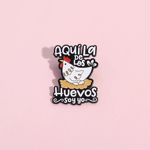 Funny white hen enamel pin with AQUÍ La DE Los Huevos SOY YO text on pink background