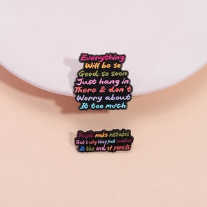 Funny colorful enamel lapel pins with inspirational English quotes on a pink background