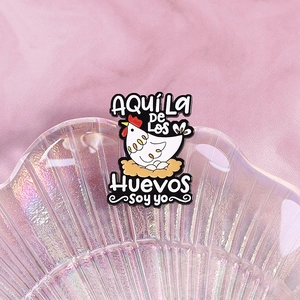 Cartoon hen and eggs enamel brooch with funny Spanish text on a shell tray