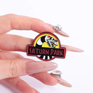 Enamel snake lapel pin badge featuring Saturn Park text and cartoon design in hand