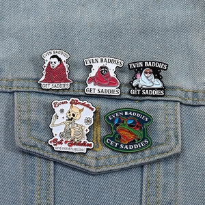 Detail of five cartoon enamel pins featuring a skull, frog, and cat on a denim jacket pocket