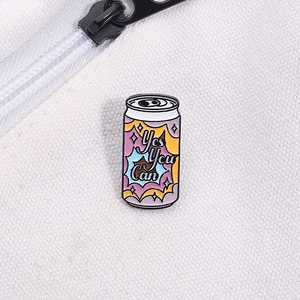 Macro shot of 'Yes You Can' colorful juice can enamel pin on white canvas fabric