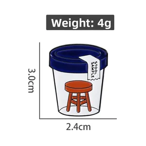 Macro detail of cartoon stool sample enamel pin showing size 3.0cm by 2.4cm and weight 4g