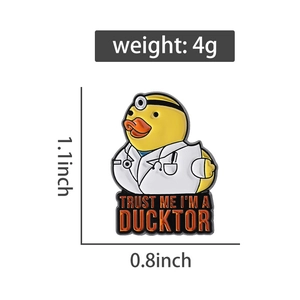 Dettaglio della spilla in smalto a forma di papera dottore con slogan 'Trust Me I'm a Ducktor'