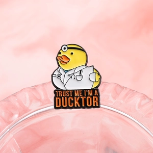 Épinglette de docteur canard jaune avec texte Trust Me I'm a Ducktor sur fond rose uni