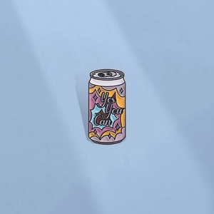Cartoon soda can enamel pin with Yes You Can text on a soft blue background