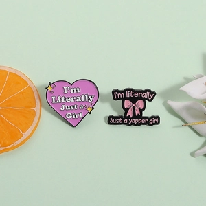 Pink heart and purple enamel pins with fun quotes on a pastel green background