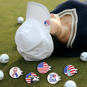 Detail van vijf Amerikaanse magnetische golfbal markers op het gras van de golfbaan