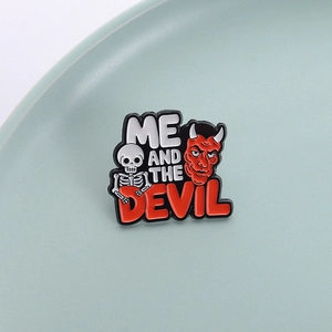 Punk style skull and red devil enamel pin with ME AND THE DEVIL text on mint plate