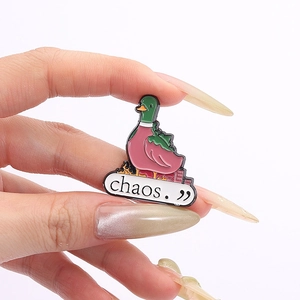Detail shot of a creative chaos green duck enamel pin with burning city design