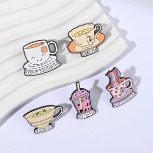 5-piece set of enamel pins with tea-themed puns on elegant white stone display