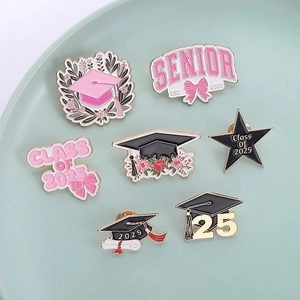 Detail of 7-piece Class of 2025 enamel graduation pins with floral and cap designs