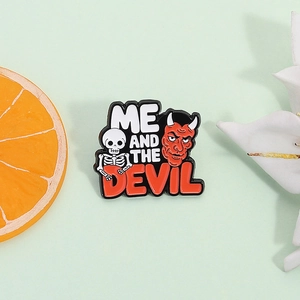 Punk enamel pin with skull and devil design featuring ME AND THE DEVIL text