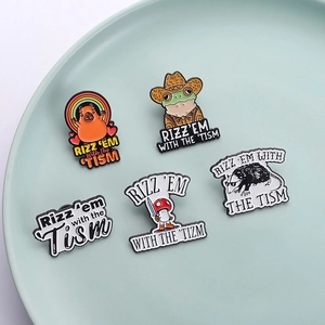 Macro shot of five enamel pins featuring frogs and capybaras on a light green tray