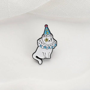 Makroaufnahme einer Emaille-Katzenbrosche mit blauem gepunktetem Clownshut und Kragen