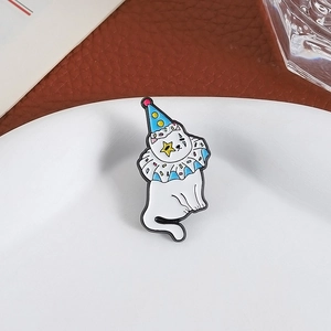 Cartoon circus cat enamel pin with party hat and star eye on a ceramic plate