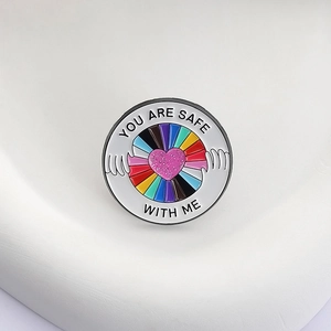 Détail de la broche en émail avec rayures arc-en-ciel et texte You Are Safe With Me