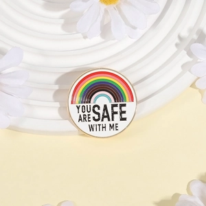Épingle arc-en-ciel en émail You Are Safe With Me sur un socle blanc élégant