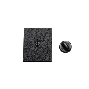 Detail view of the black metal brooch back with hammer texture and rubber clutch