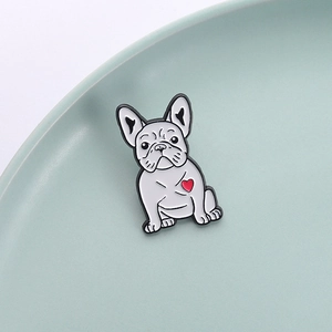 Dettaglio di una spilla in smalto a forma di bulldog bianco con un cuore rosso vivace