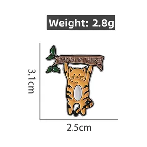 Détail d'une broche chat orange suspendu à une branche avec dimensions de 3,1 cm de haut