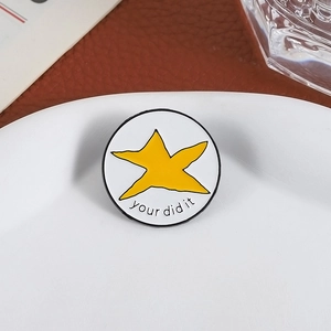 Pin's rond émaillé avec étoile jaune et texte You Did It sur assiette blanche
