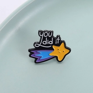 Cartoon star enamel pin with 'you did it' text on light blue tray background