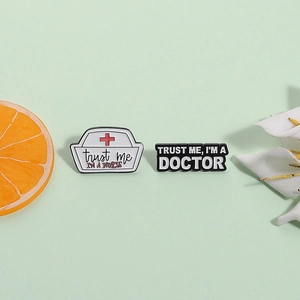 Nurse hat and doctor badges with Trust Me I'M A NURSE and DOCTOR enamel lettering