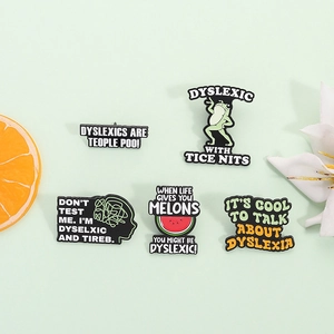 Set di 5 spillette in smalto per la dislessia con scritte creative su sfondo verde chiaro