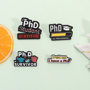 Enamel PhD student survivor pins set featuring graduation caps and books on green background