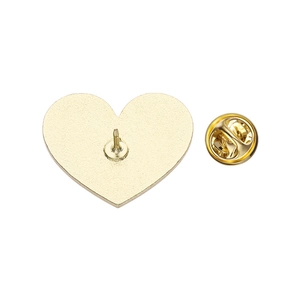 Detail of heart pin back featuring a gold metal base and butterfly clutch fastener