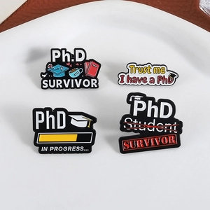 Lot de 4 pin's émaillés PhD survivor avec designs de diplôme sur une assiette blanche