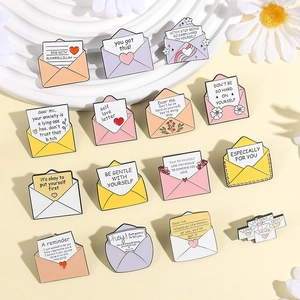 Detailed macro of enamel envelope pins featuring motivational quotes and colorful zinc alloy finish