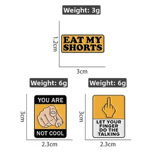 Detailed view of yellow enamel pins with bold typography and dimensions markers