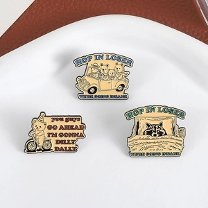 Lot de trois broches en émail chat noir mignon présentées sur une assiette en céramique