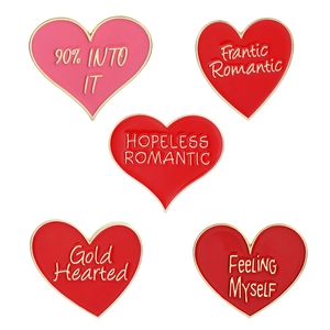 Set of 5 heart enamel pins with gold trim and slogans like Gold Hearted on white background