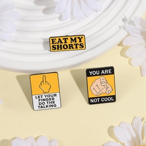 Three yellow enamel warning sign pins set with Eat My Shorts and creative finger slogans