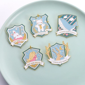 Set of five colorful animal enamel brooches featuring rabbit, whale, and elk on a tray