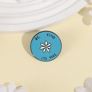 Pin's en émail marguerite avec slogan 'BE KIND IT'S FREE' sur fond bleu